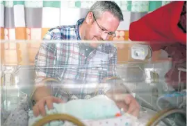  ?? PHIPPS, THE OKLAHOMAN]
[PHOTO BY SARAH ?? Zachary Pagel looks in on Bennett at the neonatal intensive care unit.
