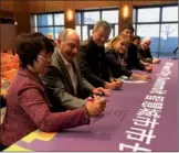  ?? LIA ZHU / CHINA DAILY ?? Members of the organizing committee sign the banner of the upcoming summit G-50 at a press briefing last week in Cupertino, California.