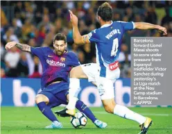  ??  ?? Barcelona forward Lionel Messi shoots to score under pressure from Espanyol midfielder Victor Sanchez during yesterday’s La Liga match at the Nou Camp stadium in Barcelona. – AFPPIX