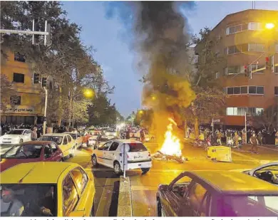  ?? West Assian News / Reuters ?? Una motociclet­a de la policía arde en una calle de Teherán durante una protesta a finales de septiembre.