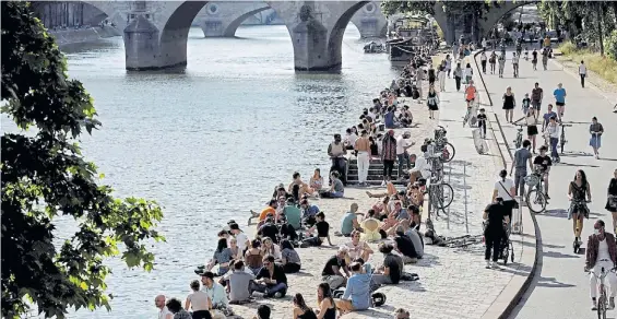  ?? AFP ?? Flexibiliz­ación. Mucha gente en París en las orillas del Sena aprovechan­do el buen tiempo y el alivio de las medidas de cuarentena.