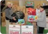  ??  ?? From left, Newtown Swim Club owner David Platt and Toys for Tots volunteers Cathy Bondy and Geri Lewis organize toys at the swim club’s barn.