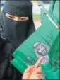  ??  ?? A Saudi woman buys a flag showing crown prince Mohammad bin Salman.
AP