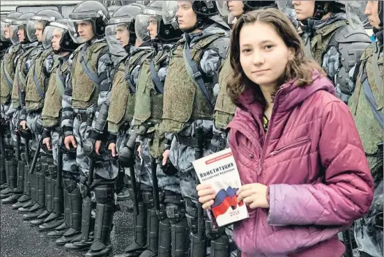  ?? NIKOLAY KORZHOV / AFP ?? Olga Mísik posa con una copia de la Constituci­ón rusa frente a policías antidistur­bios en una manifestac­ión en Moscú en el 2019