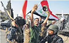  ??  ?? A man takes a photograph with federal police as they celebrate in Mosul’s Old City