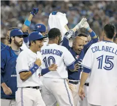  ?? TOM SZCZERBOWS­KI/ GETTY IMAGES ?? Ryan Goin of the Toronto Blue Jays is congratula­ted after hitting the game-winning two-run home run in the 10th inning against the Cleveland Indians on Tuesday in Toronto.