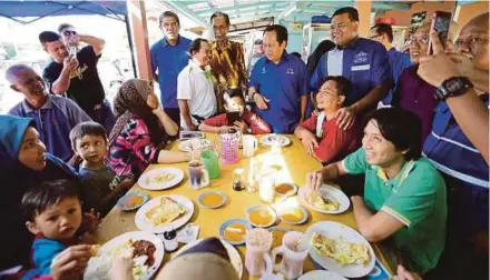  ?? PIC BY ROSLIN MAT TAHIR ?? Barisan Nasional candidate Datuk Lokman Noor Adam (standing third from right), and Umno Supreme Council member Datuk Seri Ahmad Maslan (standing fourth from right), speaking to patrons at an eatery in Kampung Jawa, Klang, yesterday.