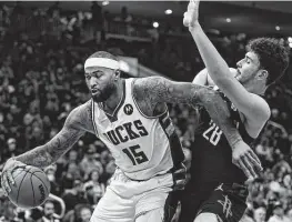  ?? Morry Gash / AP ?? DeMarcus Cousins (izq.), de los Bucks de Milwaukee, supera la marca de Alperen Sengun, de los Rockets, en el encuentro del miércoles 22 de diciembre de 2021.