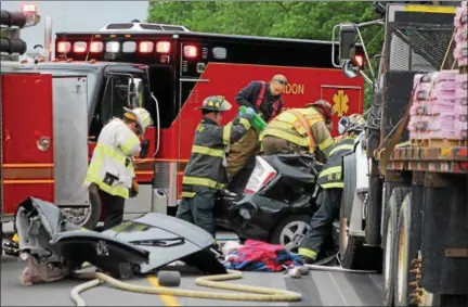  ?? KRISTI GARABRANDT — THE NEWS-HERALD ?? First responders work to remove a victim from the car involved in a crash on Route 44 in Chardon Township on June 6.