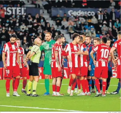  ?? BIEL ALIÑO / EFE ?? Los jugadores del Atlético protestan ante González Fuertes tras el polémico penalti del final.