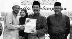  ??  ?? Ramlee presenting a certificat­e to one of the winners of the ‘Sepanduk’ competitio­n held in conjunctio­n with Maulidur Rasul.