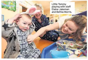  ??  ?? Little Tommy playing with staff Elaine Jakeman and Bethia Morris.