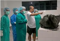  ?? AFP ?? Coroners look at the bag containing the remains of German hostage Jurgen Kantner in Jolo. —