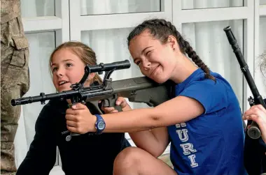  ?? PHOTO: WARWICK SMITH/FAIRFAX NZ ?? Fun with guns: Military personnel from Linton Army Base visit Whakarongo School – Maddison Brown (left) and Amy Van Leeuwen with Steyr rifle.