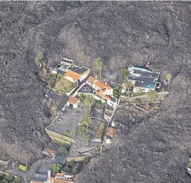  ?? Emilio morenatti/ap ?? La lava rodea un conjunto de casas en La Palma