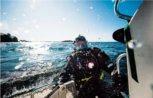  ??  ?? An archeologi­sts from Sweden’s National Maritime and Transport Museums returns from a dive on a wreck site off the coast of the town of Dalaro in the Stockholm archipelag­o. — AFP