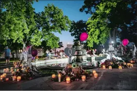  ?? WONG MAYE-E/AP PHOTO ?? Candles are lit at dawn Friday at a memorial site in the town square for the victims killed in this week’s elementary school shooting in Uvalde, Texas.