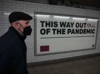  ?? Matt Dunham, Associated Press file ?? A man wearing a face mask to curb the spread of coronaviru­s walks past a health campaign poster in an underpass leading to Westminste­r undergroun­d train station, in London on Jan. 27.