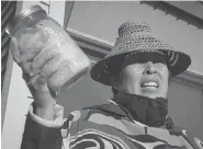  ?? DARRYL DYCK / THE CANADIAN PRESS ?? Christine Smith-Martin, of the Tsimshian First Nation, holds a jar of salmon before the government announced the approval of the Pacific NorthWest LNG project.