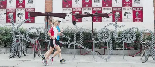  ?? MICHELLE SIU/THE CANADIAN PRESS ?? Christiane Nilles from Luxembourg, left, runs through Toronto’s Kensington Market with Toronto Guided Runs founder Sue Pulfer.