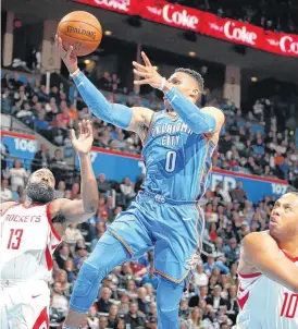  ?? [PHOTO BY BRYAN TERRY, THE OKLAHOMAN] ?? Oklahoma City’s Russell Westbrook goes to the basket between Houston’s James Harden and Eric Gordon during Tuesday’s game at Chesapeake Energy Arena.