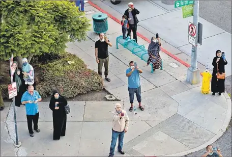  ?? Irfan Khan Los Angeles Times ?? PEOPLE pause outside King Fahad Mosque, one of many Southern California mosques permitted to broadcast the call to prayer.