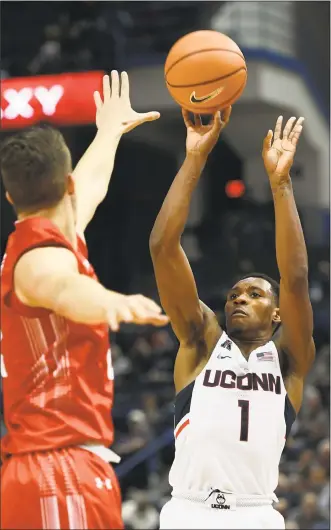  ?? Jessica Hill / Associated Press ?? UConn’s Christian Vital, right, shoots over Boston University's Tyler Scanlon during the second half Sunday in Hartford. Vital scored a career-high 30 points in the Huskies’ win.