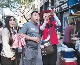  ?? AFP ?? THIS PHOTO taken on May 18, shows a South Korean guide directing tourists in the popular Myeongdong shopping area of Seoul.