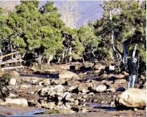  ??  ?? Cables de energía. Un hombre permanece de pie junto a unos cables de energía dañados por el alud de lodo con rocas en Montecito, California.