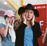  ?? Carolyn Kaster / Associated Press ?? Jenna Raspanti and other Delta passengers spend anxious moments in line Monday at the Delta counter at Ronald Reagan Washington National Airport.