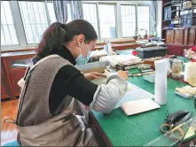  ?? WEN JING / XINHUA ?? Restorer Yao Jiadi works at her office in the Tianshui Library in Gansu province on Dec 14.