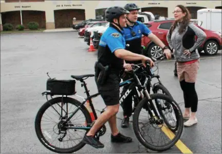  ?? TAWANA ROBERTS — THE NEWS-HERALD ?? Painesvill­e Police Sgt. Josh Rogers and Patrolman Vince Crews talks with Eastern Lake County Chamber of Commerce Membership Manager Katrina March at the Party on Main event on May 18.