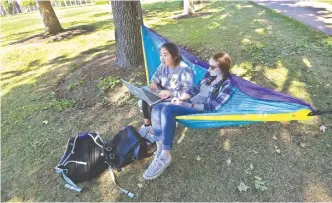  ?? — AFP ?? MISSOURI: Students Elizabeth (L) and Marni study outside the site of the second US Presidenti­al debate on October 8, 2016, at Washington University in St. Louis.