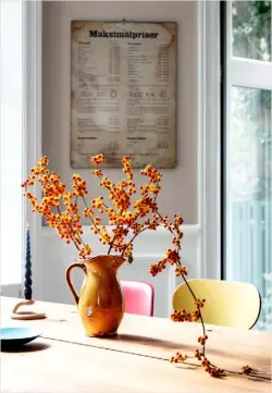  ??  ?? Kitchen The light, bright feel of the space is accentuate­d by the pop of colour brought by bespoke navy cabinets and a splashback of salmon pink tiles – for similar, try Ca’Pietra. Behind the table hangs a poster from an old butcher’s shop, which lists the prices for different cuts of meat during WWII