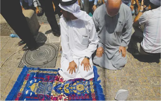  ??  ?? PALESTINIA­NS PRAY just outside Jerusalem’s Old City in protest over the installati­on of metal detectors at the entrance to the Temple Mount this week.