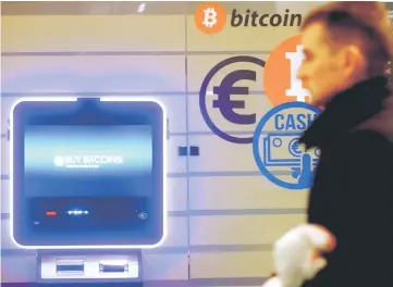  ??  ?? A man walks past a bitcoin ATM in Vilnius, Lithuania on Dec 6. — Reuters photo