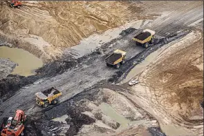  ??  ?? Heavy haulers work at the Suncor Energy Inc. Millennium mine in this aerial photo taken in September over the Athabasca oil sand in Alberta, Canada. Bloomberg/BEN NELMS