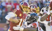  ?? MARK TENALLY/AP ?? Washington Redskins quarterbac­k Alex Smith is sacked by Atlanta Falcons defensive tackle Grady Jarrett on Sunday.