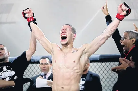  ??  ?? Amateur fighter Martin Justiz celebrates a win at an MMA competitio­n run by 305 Fights in Miami Gardens on Feb. 3. The event showcased up-and-coming-fighters and musical artists.