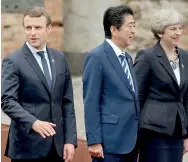  ??  ?? From left : France's President Emmanuel Macron, Japan's Prime Minister Shinzo Abe and Britain's Prime Minister Theresa May pose for a family photo at the Greek Theatre during the G7 Summit in Taormina, in Sicily. AFP