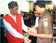  ?? ADI WIJAYA/JAWA POS ?? INGIN PLEIDOI: Rochiem didampingi penasihat hukum, Rizal, bersiap meninggalk­an ruang sidang Pengadilan Negeri Gresik.