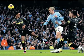  ?? MARTIN RICKETT BacpagePix ?? MANCHESTER City’s Erling Haaland, centre, heads wide of goal against Aston Villa during a Premier League match at the Etihad Stadium, Manchester on Sunday. |