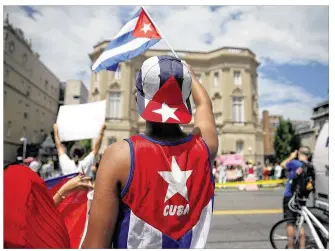  ?? MARKWILSON / GETTY IMAGES ?? Cuba supporterD­anial Espino Delgadowav­es a Cuban flflag in front of the country’sembassy after it reopened Monday for the fifirst time in 54 years inWashingt­on, D.C. Theembassy­was closed in 1961when the U.S. severed diplomatic ties with the island...