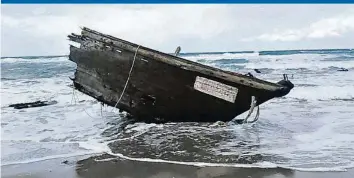  ??  ?? Japanische Insel Sado: An der Küste wurde der abgebroche­ne Bug eines Holzbootes angespült. REUTERS