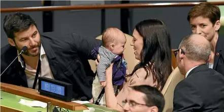  ?? AFP ?? Prime Minister Jacinda Ardern kisses her daughter Neve, as her partner Clarke Gayford, left, looks on during the Nelson Mandela Peace Summit in New York. The infant sat in her mother’s lap for the historic debate at the UN.