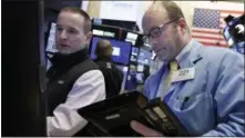  ?? RICHARD DREW — THE ASSOCIATED PRESS ?? Trader Peter Mancuso, right, works on the floor of the New York Stock Exchange, Thursday.