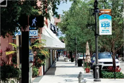  ?? JOSEPH FORZANO/THE PALM BEACH POST ?? A lone person stands on the sidewalk of Clematis Street in West Palm Beach amid the spring 2020 business shutdown during to the initial coronaviru­s outbreak.