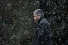  ?? MATT SLOCUM — THE ASSOCIATED PRESS ?? A man walks through falling snow Tuesday in Philadelph­ia. The National Weather Service says a powerful storm packing heavy, wet snow and strong winds could dump up to 18 inches of snow in some locations on Wednesday.