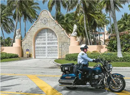  ?? GIORGIO VIERA/GETTY-AFP ?? An officer rides past the gates of former President Donald Trump’s Mar-a-Lago estate on Tuesday in Palm Beach, Florida.