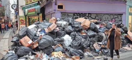  ?? BERTRAND GUAY/AFP VIA GETTY IMAGES ?? Garbage is piled on the street in Paris’ 5th district Friday as sanitation workers extended their 12-day strike. Also on Friday, crowds halted cars along a Paris ring road and blocked university campuses.